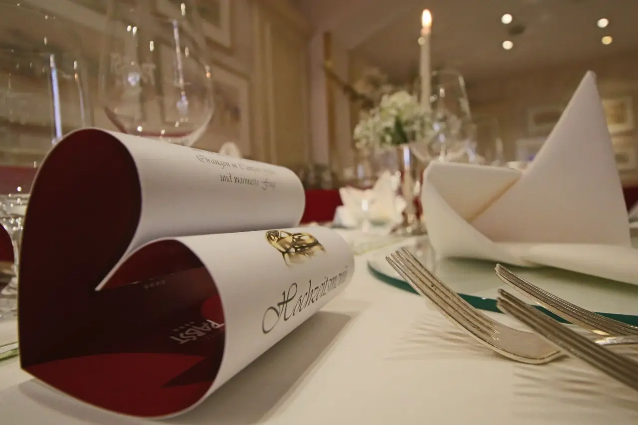 Festlich gedeckter Tisch mit Hochzeitsmenü, Besteck und Kerzenlicht im Restaurant des Hotel Pabst.
