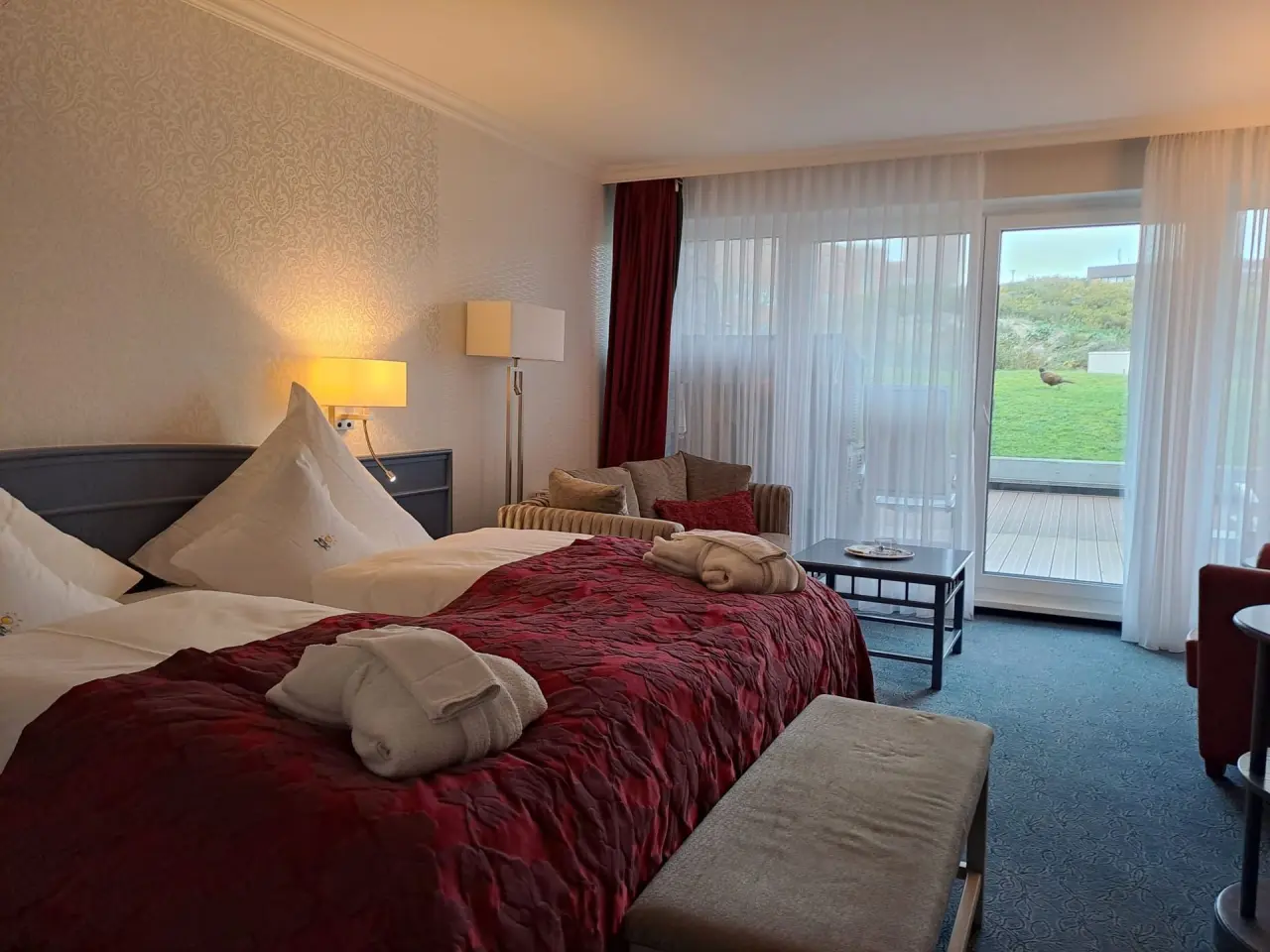 Gemütliches Hotelzimmer im Hotel Pabst mit Doppelbett, Sitzbereich und Balkonblick ins Grüne.