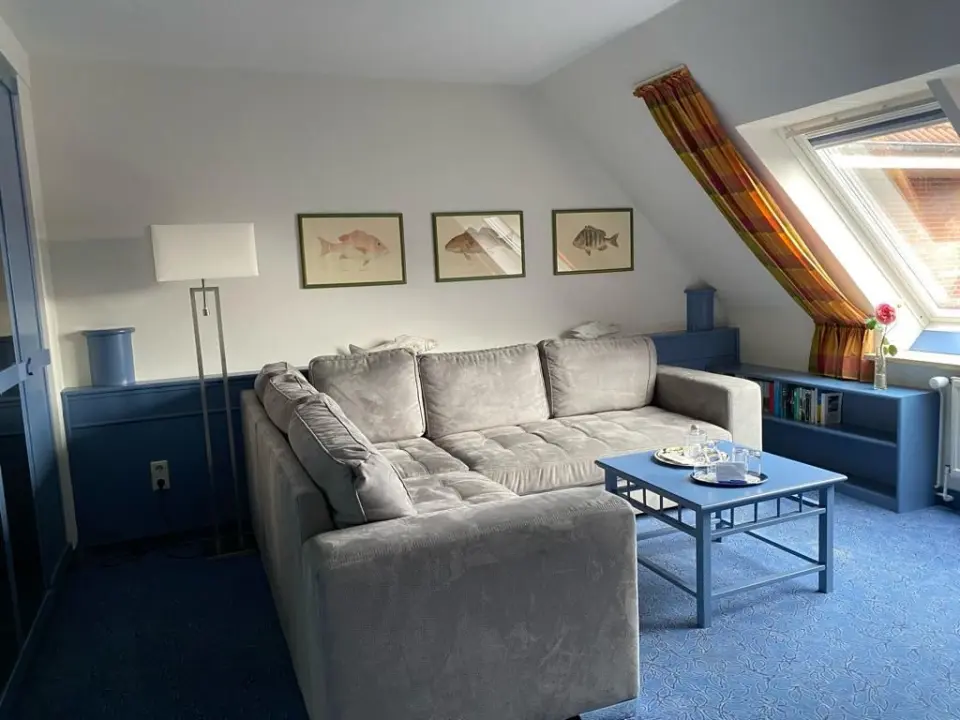 Gemütlicher Wohnbereich in einer Suite des Hotel Pabst mit Sofa, Couchtisch und Dachfenster.