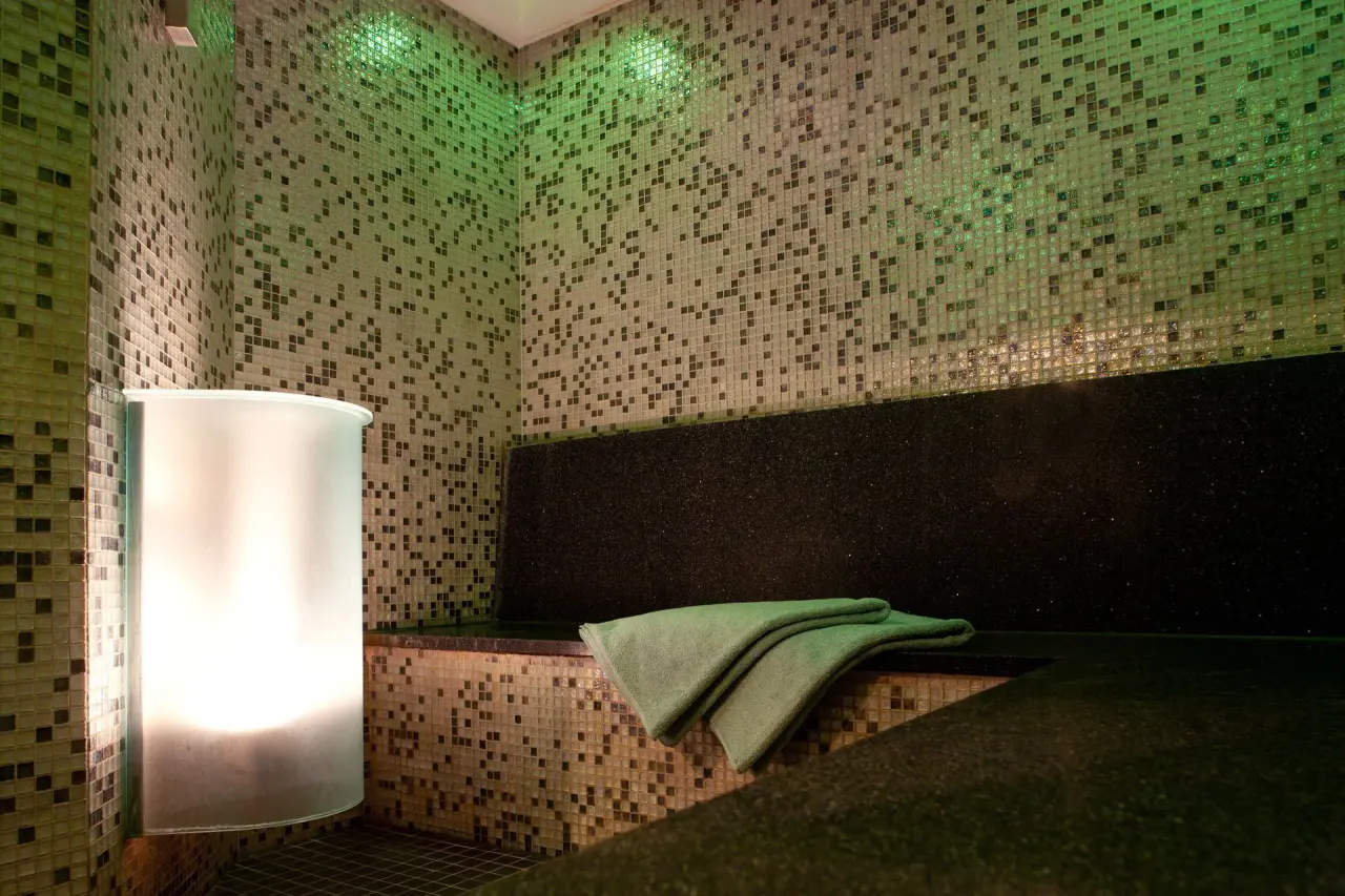 Modernes Dampfbad mit Mosaikfliesen und stimmungsvoller Beleuchtung im Wellnessbereich des Hotel Pabst.