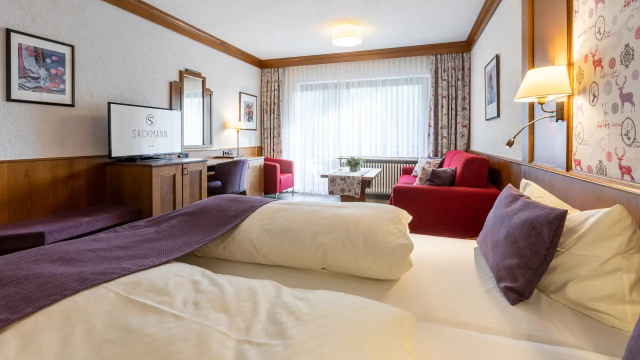 Gemütliches Hotelzimmer im Genusshotel Sackmann mit Doppelbett, Sitzbereich und Schreibtisch. Ideal für entspannte Aufenthalte.