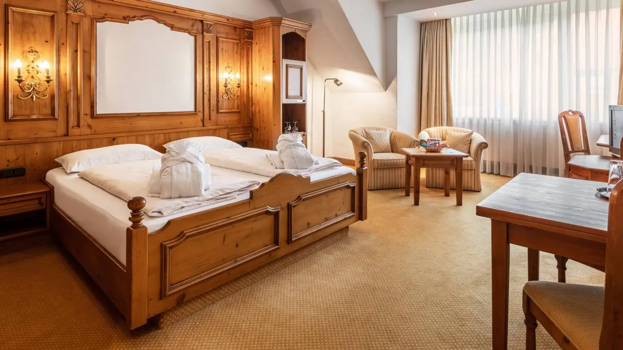 Gemütliches Doppelzimmer mit traditioneller Holzvertäfelung und Bademänteln im Vila Vita Burghotel Dinklage.
