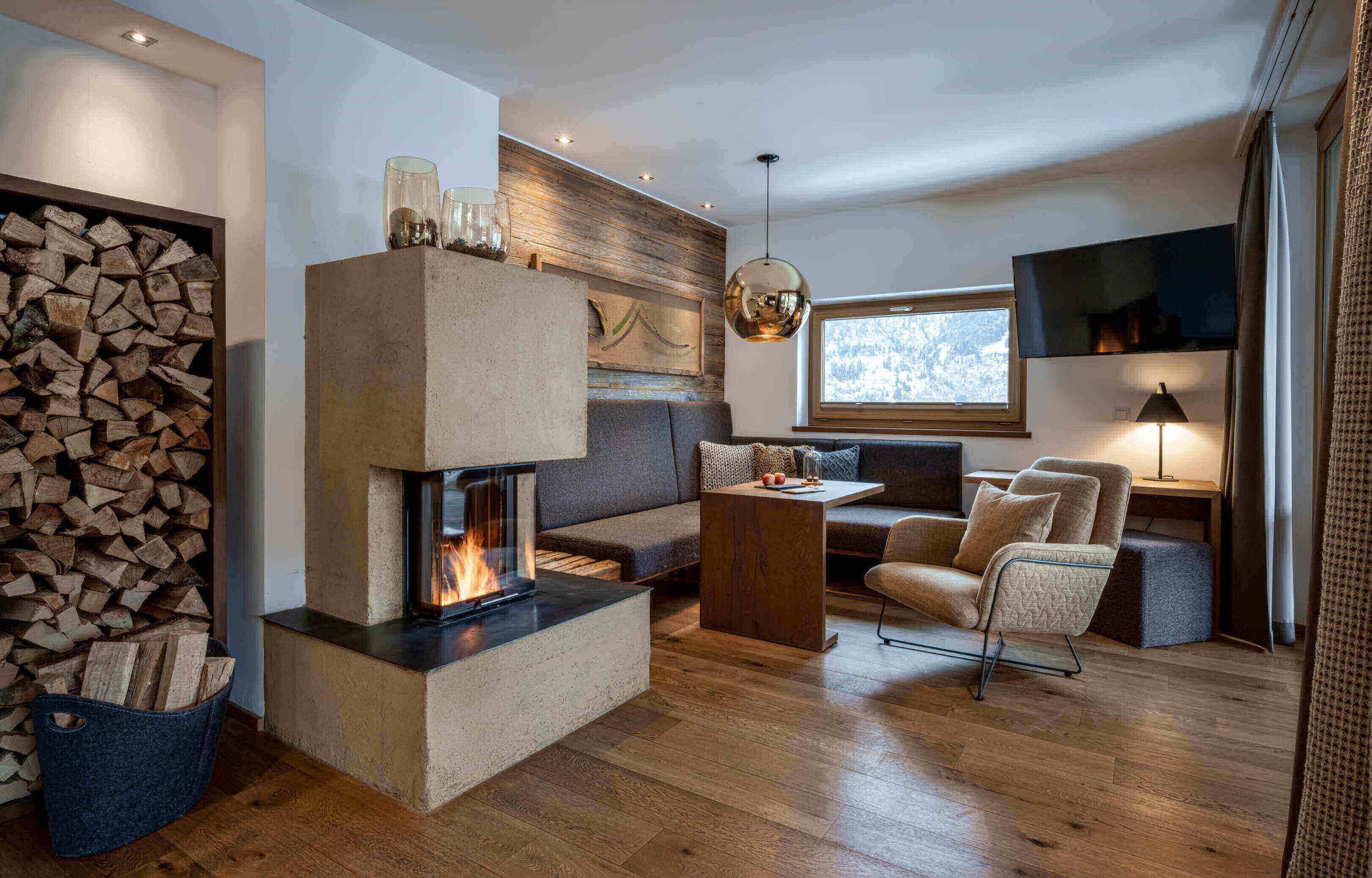 DAS.GOLDBERG in Bad Hofgastein – Gemütliches Wohnzimmer mit Kamin und Holzelementen | Wellnesshotel Gasteinertal