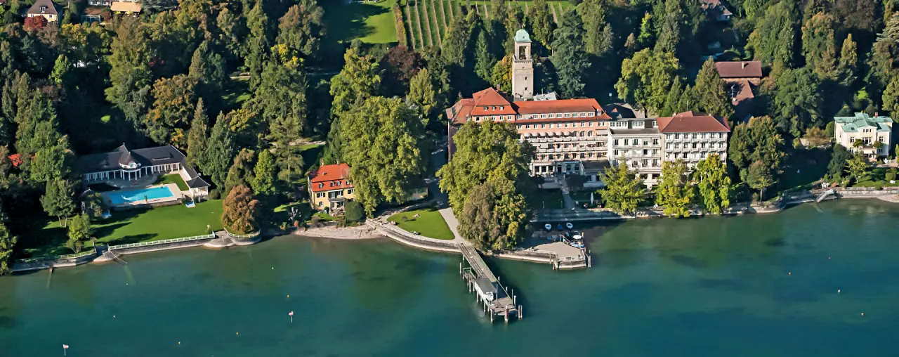 Luftaufnahme des Hotel Bad Schachen am Bodensee mit weitläufiger Anlage, Pool und privatem Bootssteg.