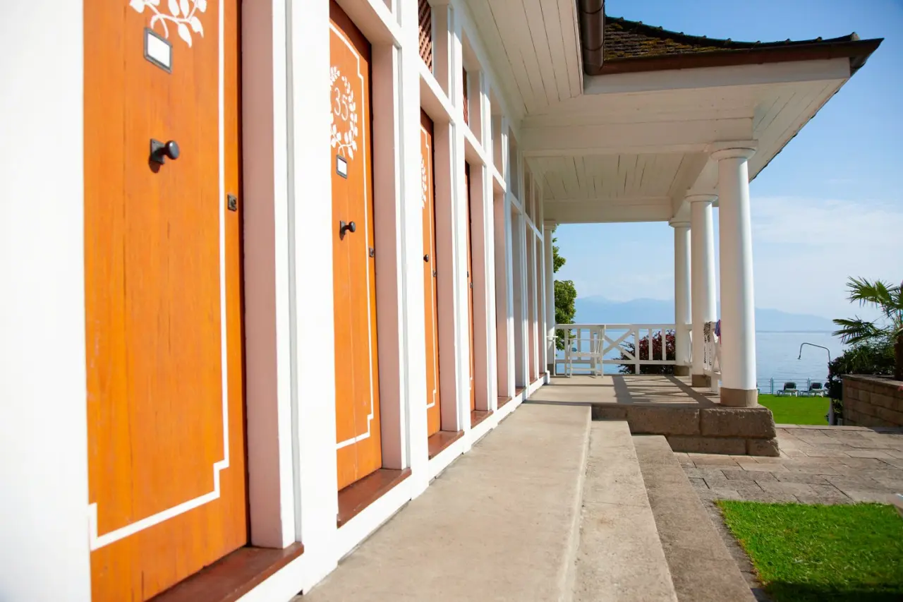 Historische Badekabinen am Ufer des Bodensees mit Bergblick im Hotel Bad Schachen.