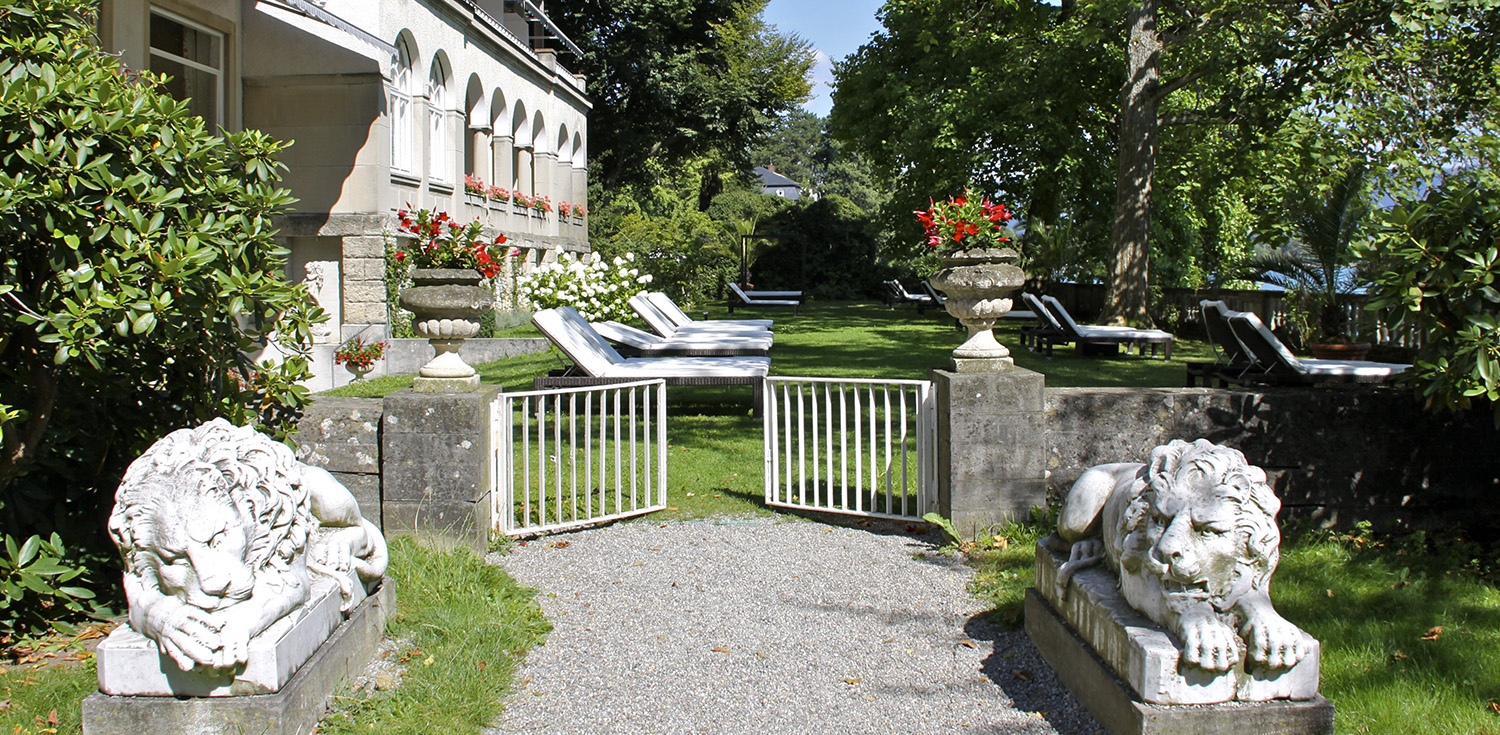 Hotel Bad Schachen in Lindau – Hotelgarten mit Liegestühlen und historischen Statuen | Wellnesshotel Bodensee