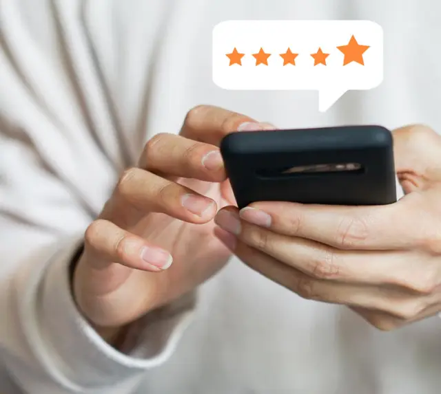 Hände halten Smartphone mit 5-Sterne-Bewertung, symbolisiert positive Gaesteerfahrung im Naturparkhotel Adler St. Roman.