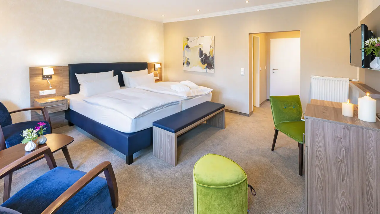 Gemütliches Doppelzimmer im Hotel Noltmann-Peters mit bequemen Betten, Sitzbereich und moderner Einrichtung.