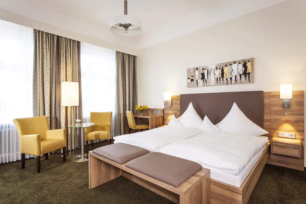 Helles, komfortables Doppelzimmer im Hotel Noltmann-Peters mit gemütlicher Sitzecke, Schreibtisch und modernem Design.