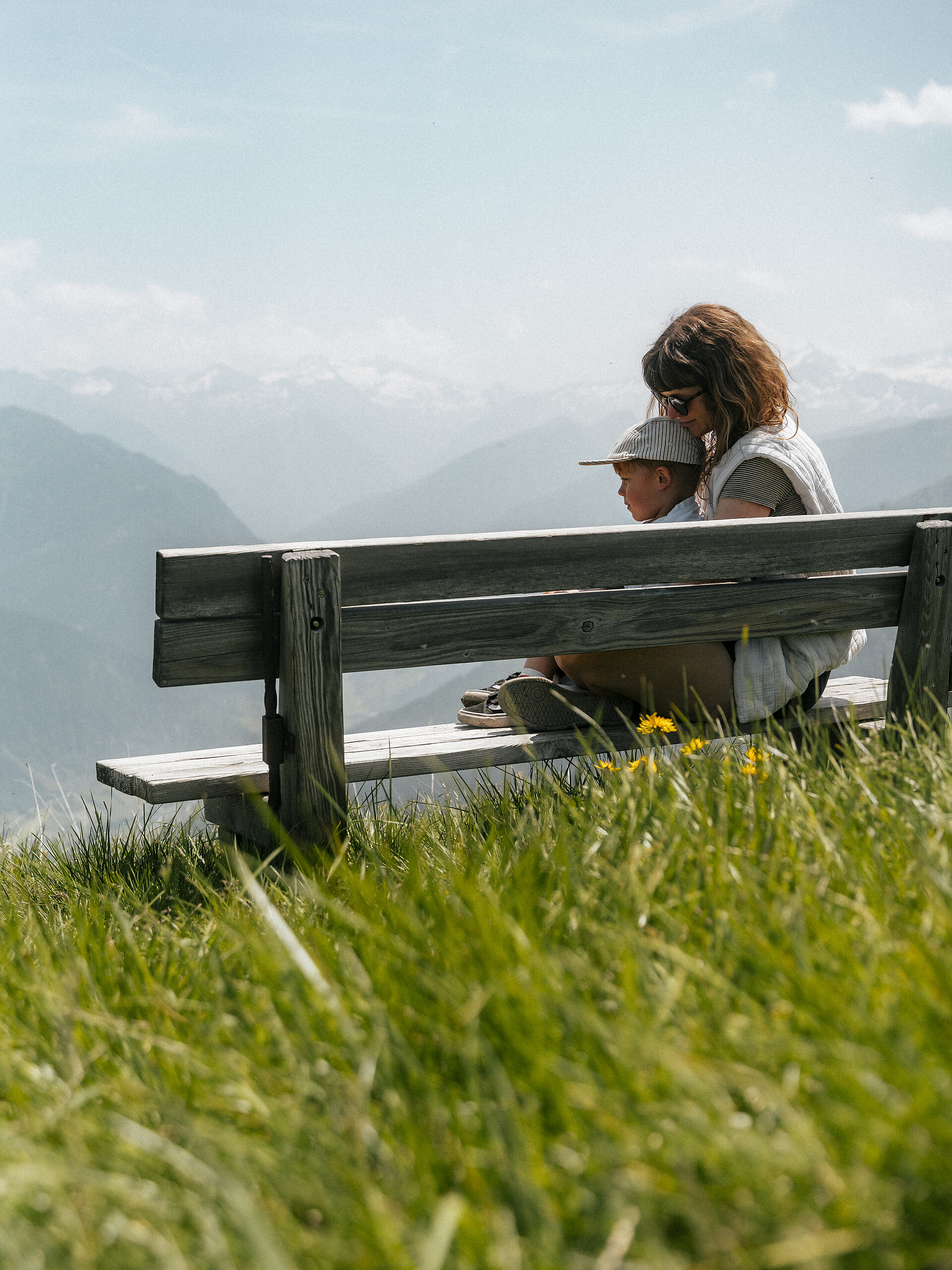 Hotel Tauernhof in Großarl – Mutter und Kind auf einer Bank mit Blick auf die Alpen | Wellnesshotel Salzburger Land