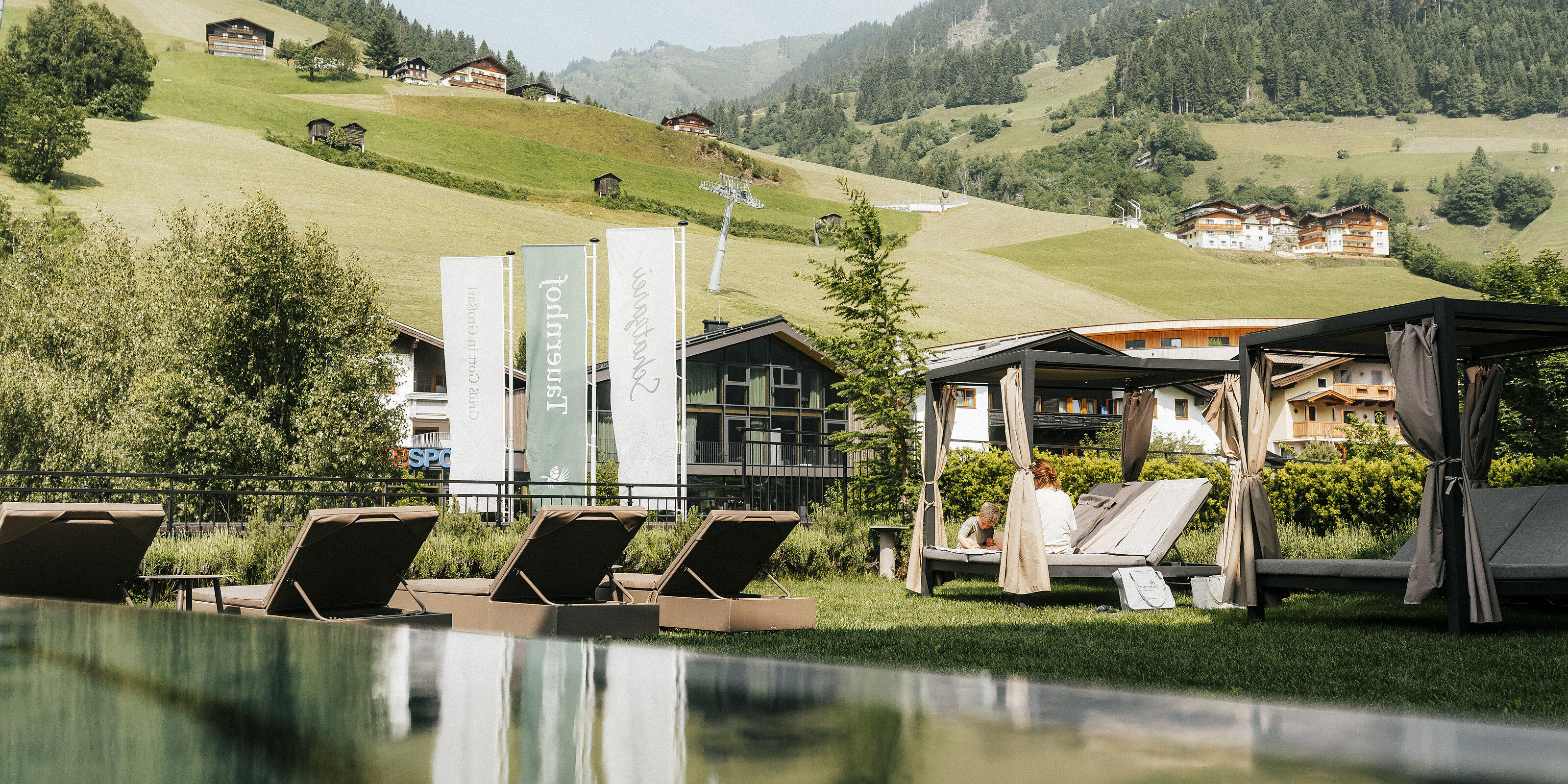 Hotel Tauernhof in Großarl – Infinity-Außenpool mit Liegen und Bergblick | Wellnesshotel Salzburger Land