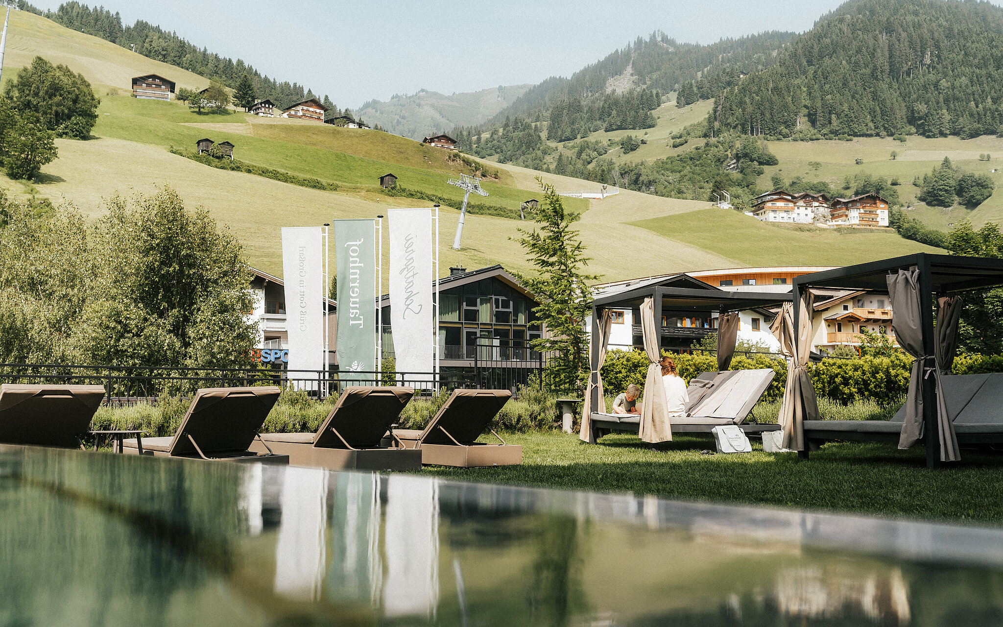 Hotel Tauernhof in Großarl – Infinity-Außenpool mit Liegen und Bergblick | Wellnesshotel Salzburger Land