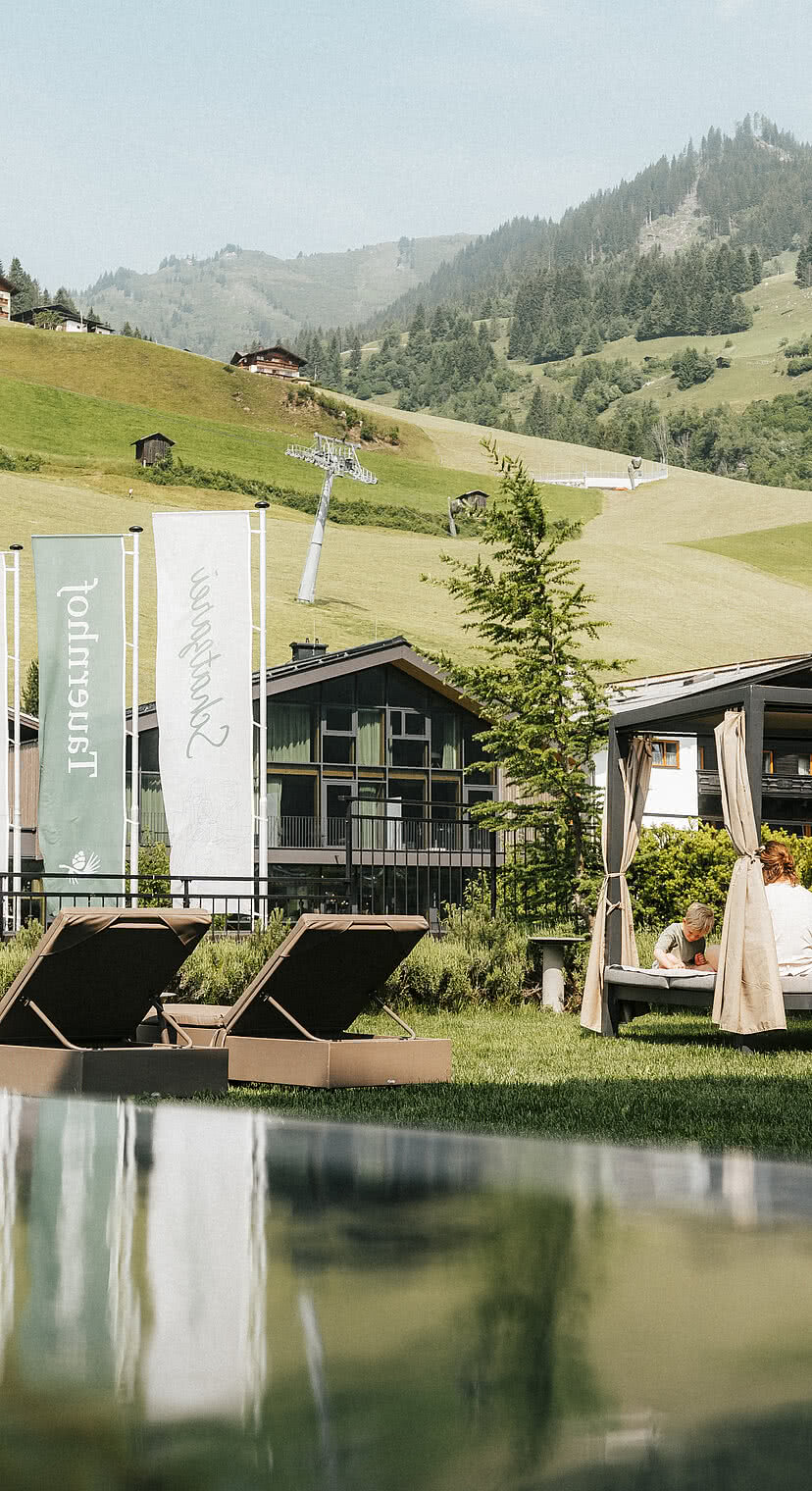 Hotel Tauernhof in Großarl – Infinity-Außenpool mit Liegen und Bergblick | Wellnesshotel Salzburger Land
