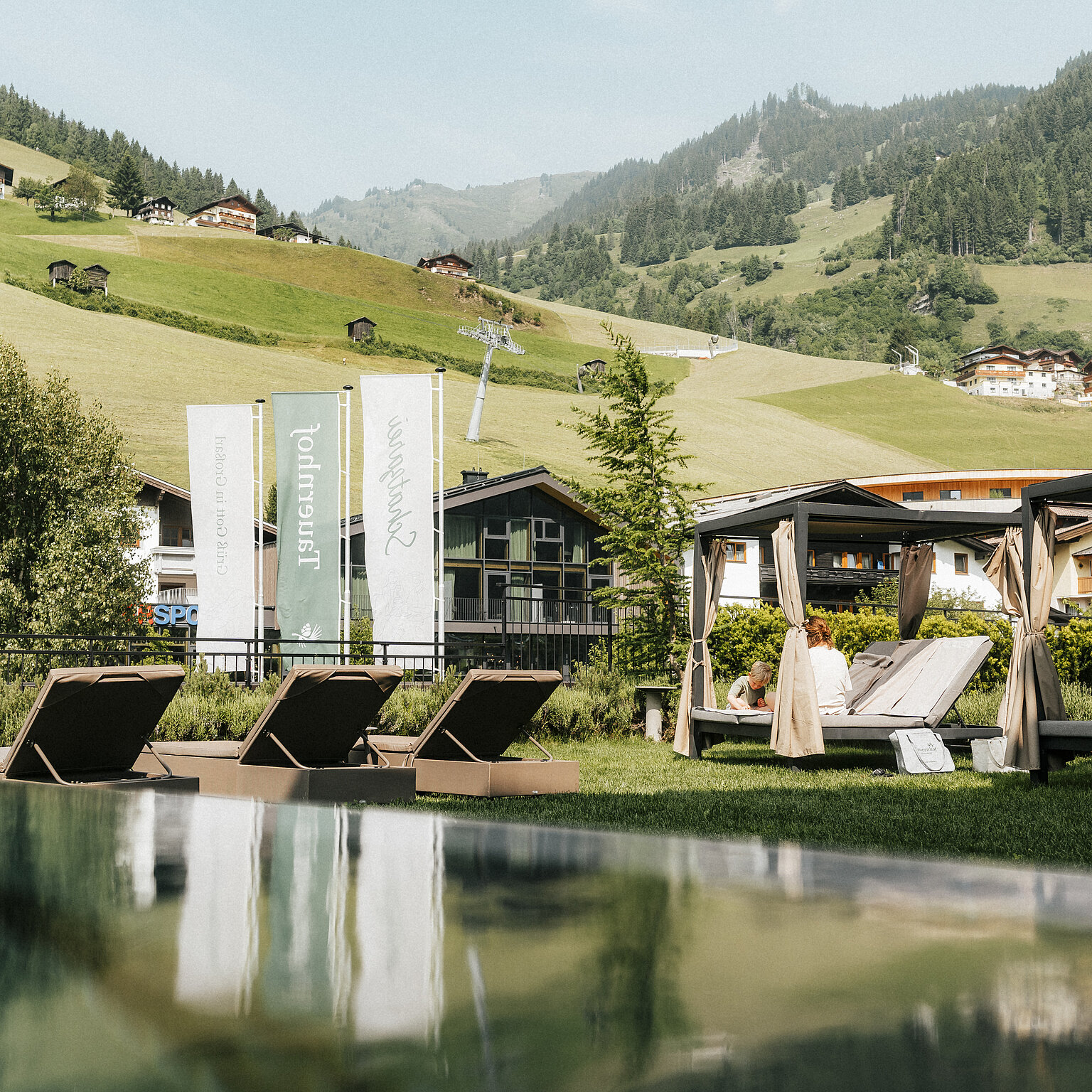 Hotel Tauernhof in Großarl – Infinity-Außenpool mit Liegen und Bergblick | Wellnesshotel Salzburger Land