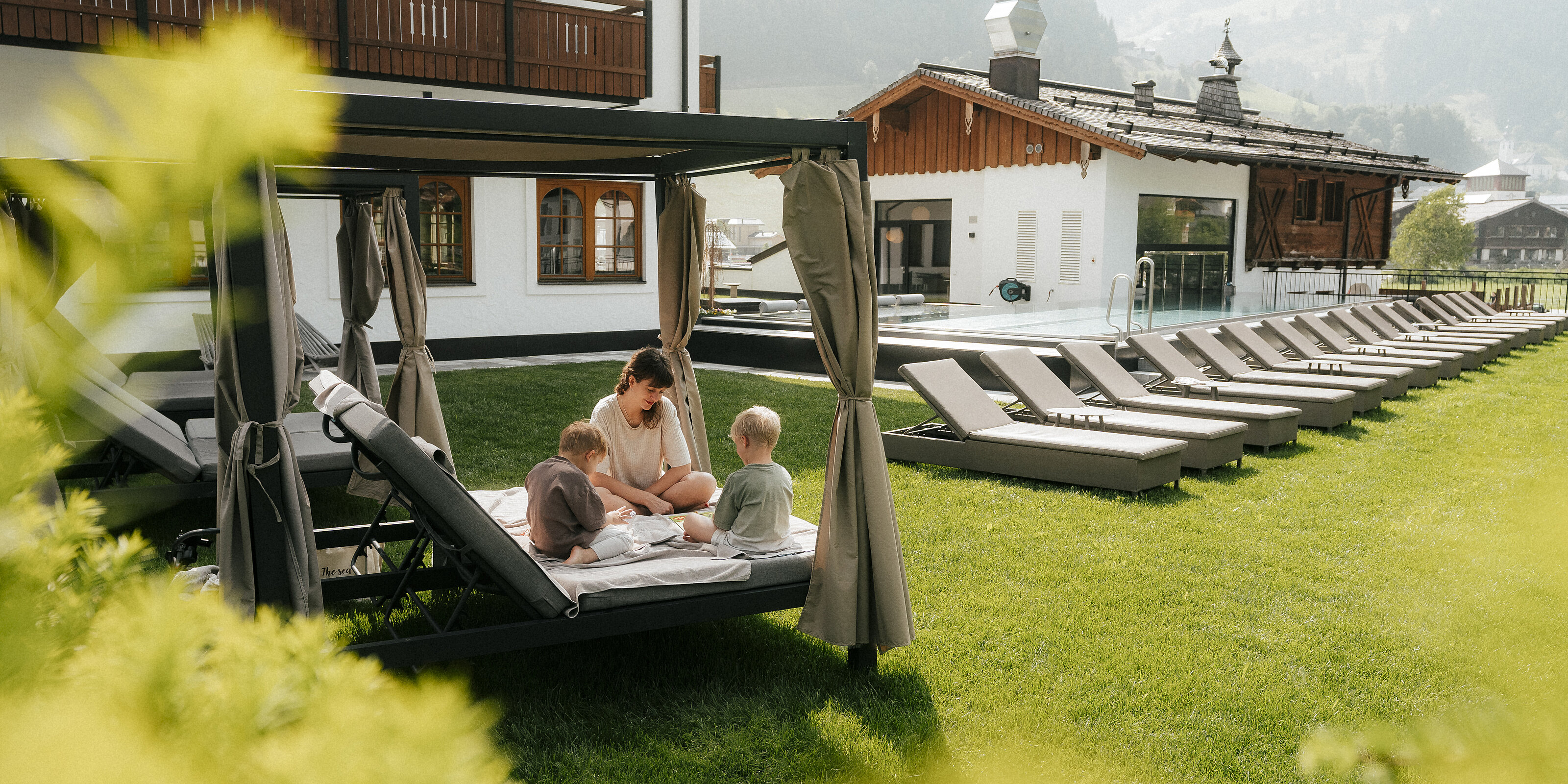 Hotel Tauernhof in Großarl – Außenpool mit Liegen und Familien-Relax-Lounge | Wellnesshotel Salzburger Land