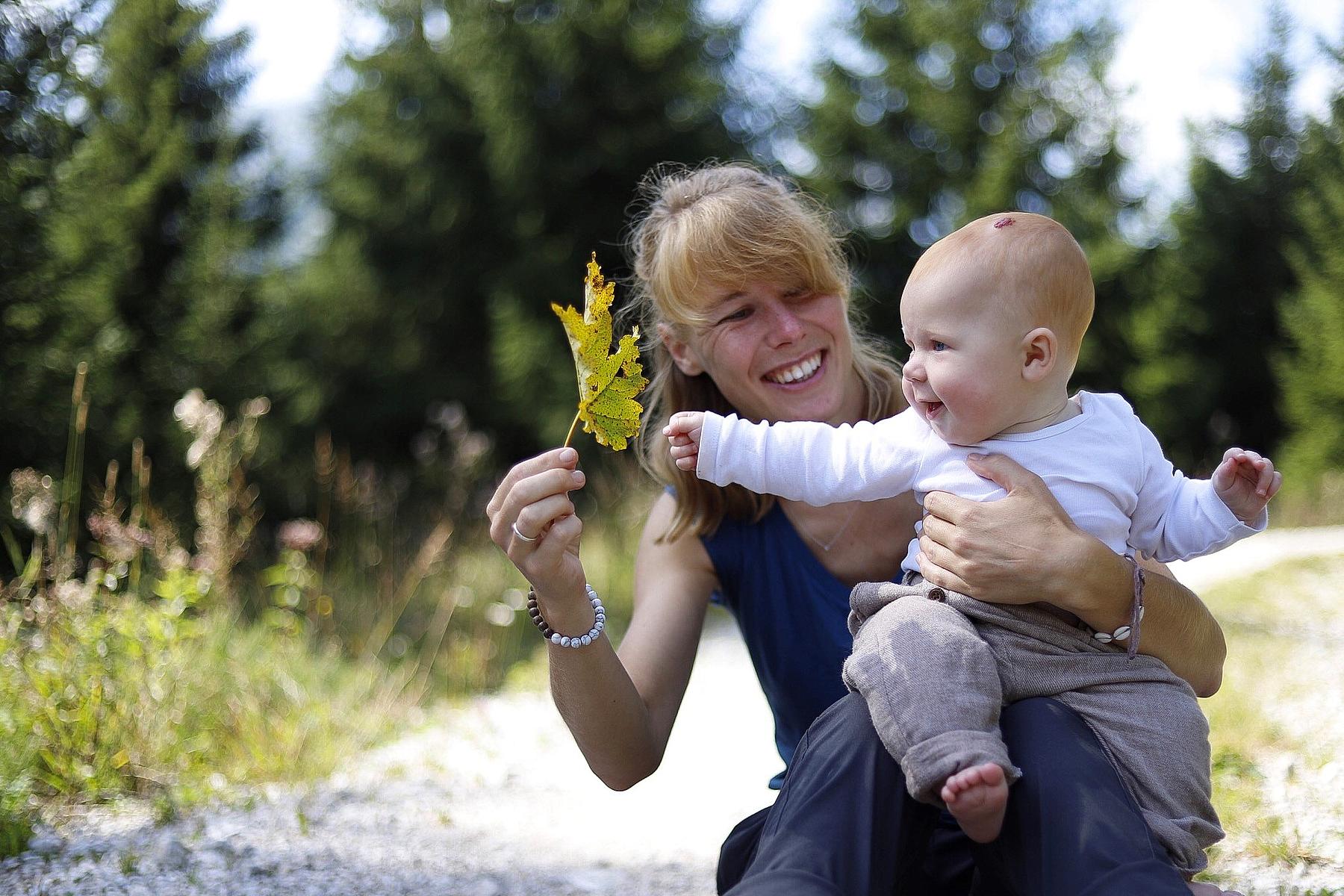 Familienparadies Sporthotel Achensee in Achenkirch – Mutter und Baby beim Spielen in der Natur | Wellnesshotel Achensee