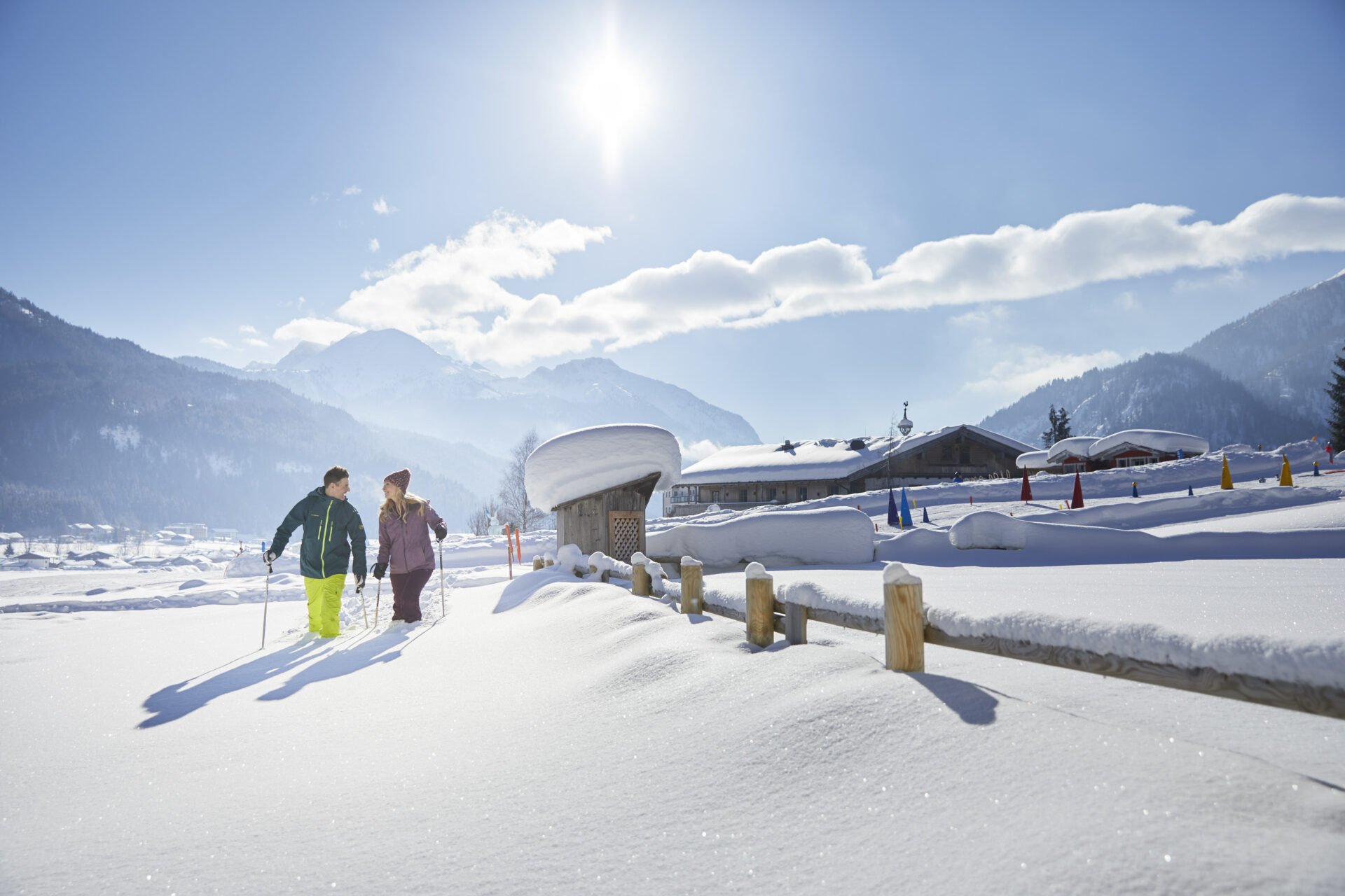 Familienparadies Sporthotel Achensee in Achenkirch – Paar beim Winterwandern in der verschneiten Bergwelt | Wellnesshotel Achensee