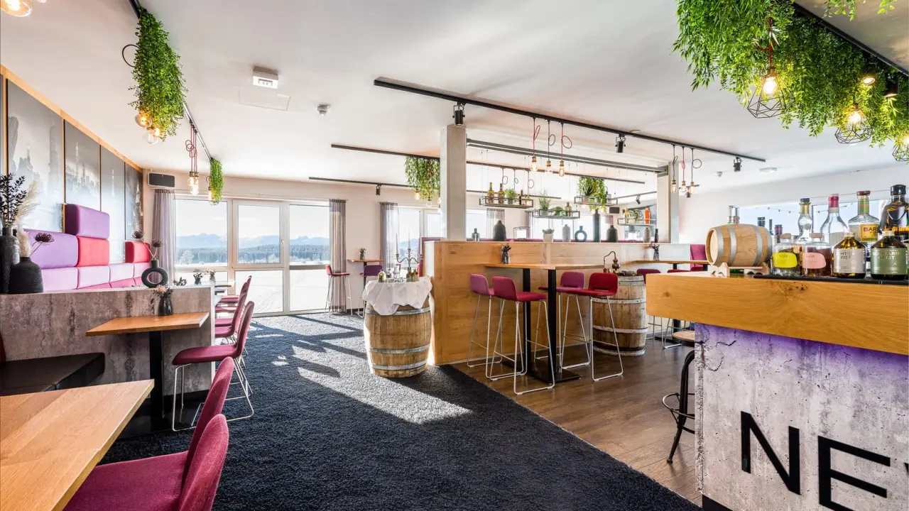 Modernes Restaurant und Bar mit Alpenblick im Hotel Das Weitblick Allgäu. Gemütliche Atmosphäre mit Pflanzen und Holzelementen.