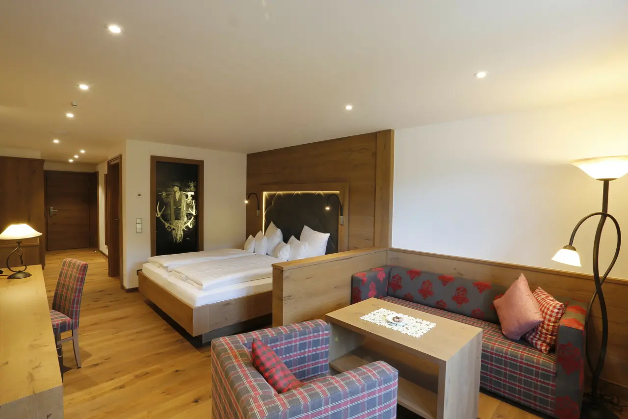 Gemütliches Doppelzimmer im Enztalhotel mit Holzboden, bequemen Betten und einer Sitzecke im traditionellen Stil.