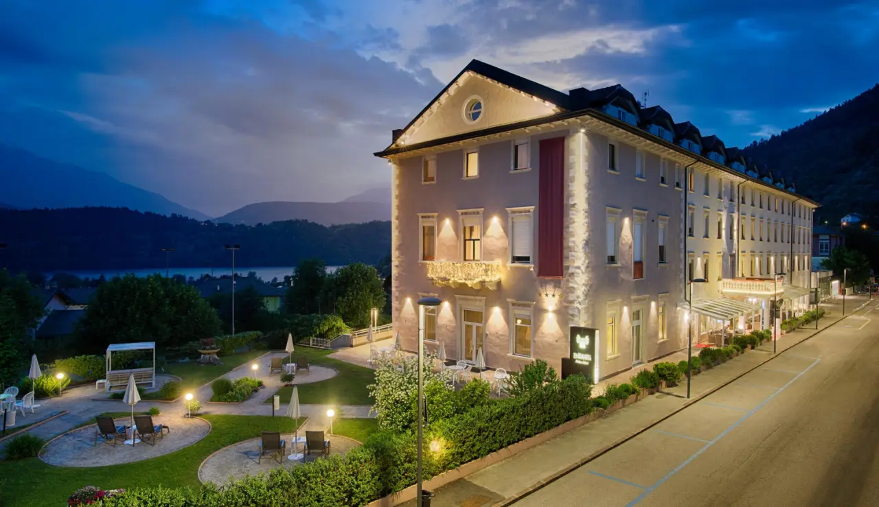 BellaVista Relax Hotel in Levico Terme – Beleuchtete Außenansicht mit Garten und Seeblick | Wellnesshotel Trentino