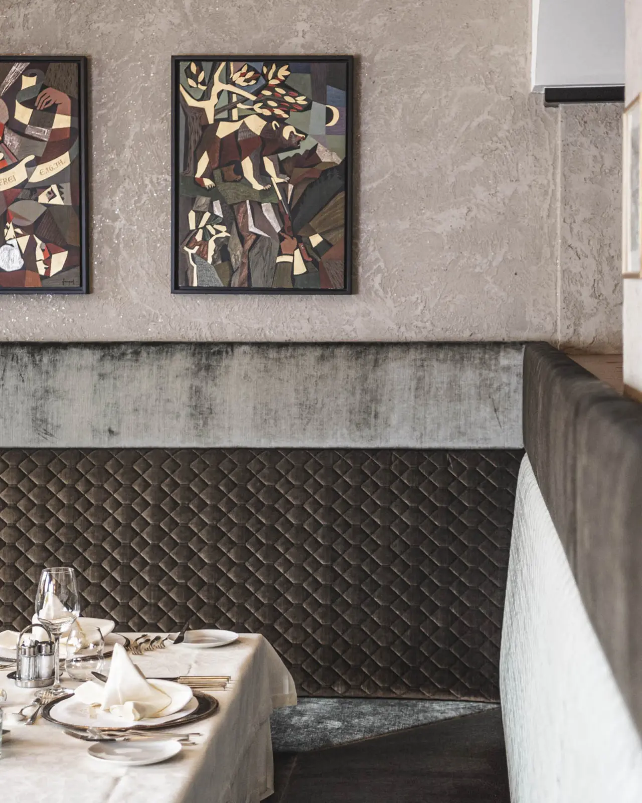 Elegant gedeckter Tisch in einem Restaurantbereich des Wellness Hotel Cervosa***** mit Kunst an der Wand.