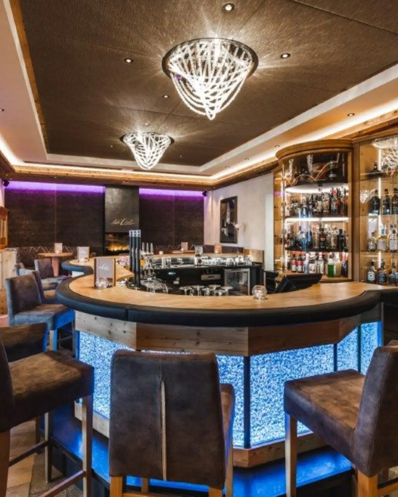 Moderne Hotelbar mit leuchtendem Tresen und gemütlichen Sitzgelegenheiten im Wellness Hotel Cervosa.