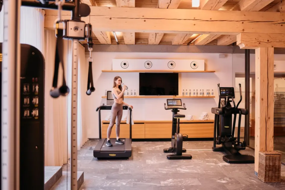 Modernes Fitnessstudio mit Technogym-Geräten und Holzbalkendecke im G’Schlössl Murtal.