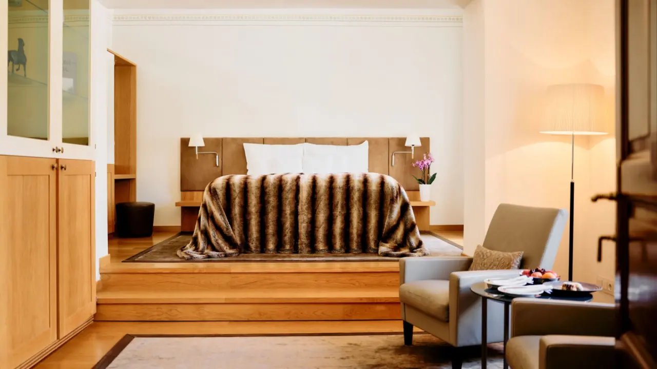 Luxuriöses Doppelzimmer mit erhöhtem Bett und gemütlicher Sitzecke im G’Schlössl Murtal.