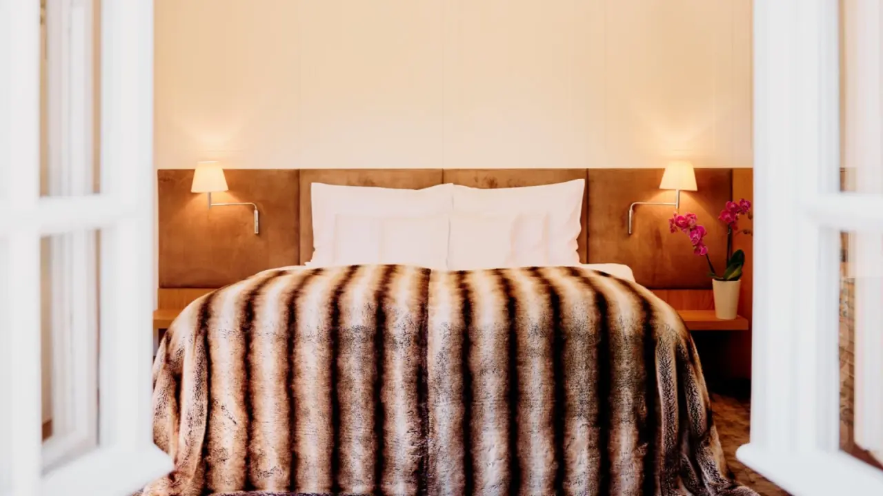 Gemütliches Doppelzimmer mit elegantem Bett und Orchidee im G’Schlössl Murtal.