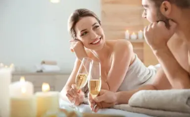 Paar entspannt im Spa-Bereich mit Champagner und Kerzenlicht im Konsum Berghotel Oberhof.