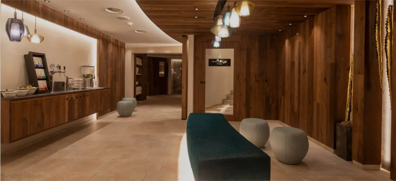 Moderner Spa-Lounge-Bereich mit Teebar und Zugang zum In- & Outdoor Pool im Hotel Post Ischgl.