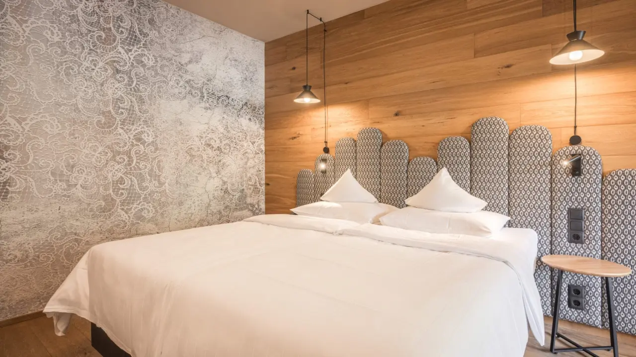Gemütliches Doppelzimmer im Almhof Family Resort & SPA mit modernem Design und Holzelementen.