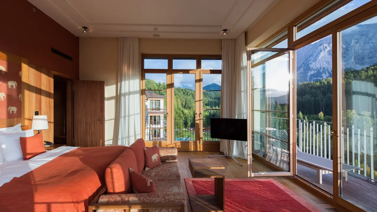 Luxuriöses Hotelzimmer im Schloss Elmau mit Balkon und atemberaubendem Bergblick auf die Alpen.