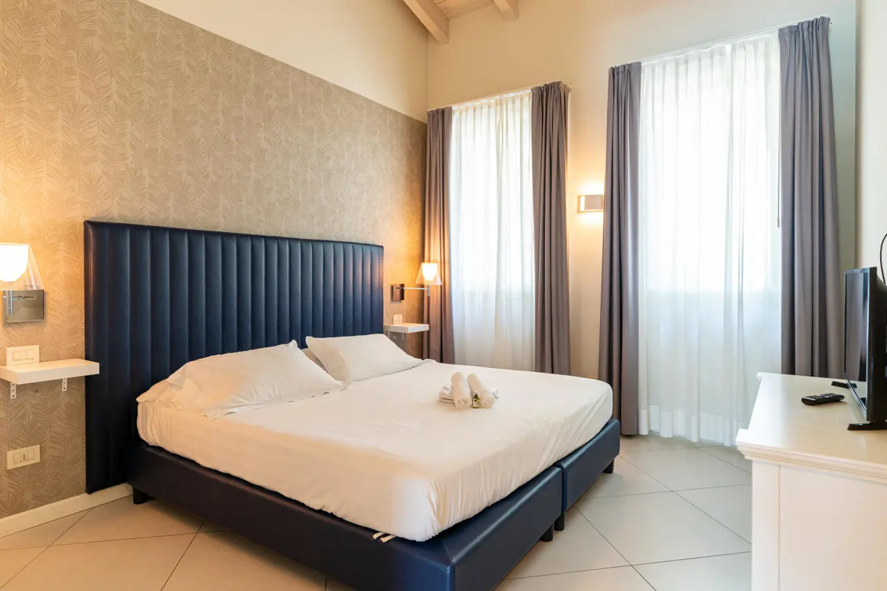 Monastero Resort & SPA in Soiano del Lago – Modernes Doppelzimmer mit blauem Polsterbett | Wellnesshotel Gardasee