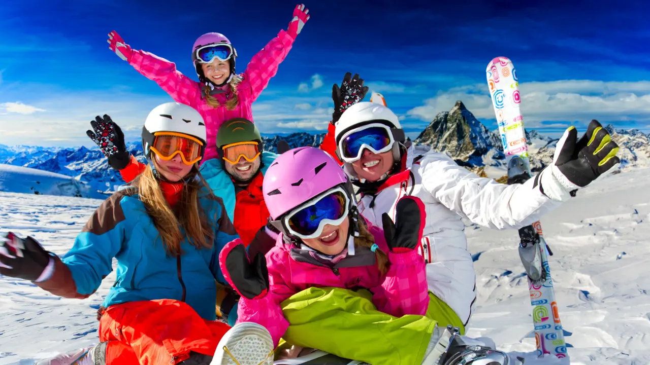 Glückliche Familie beim Skifahren in den verschneiten Bergen rund um den Waidringer Hof. Winterurlaub mit Kindern.