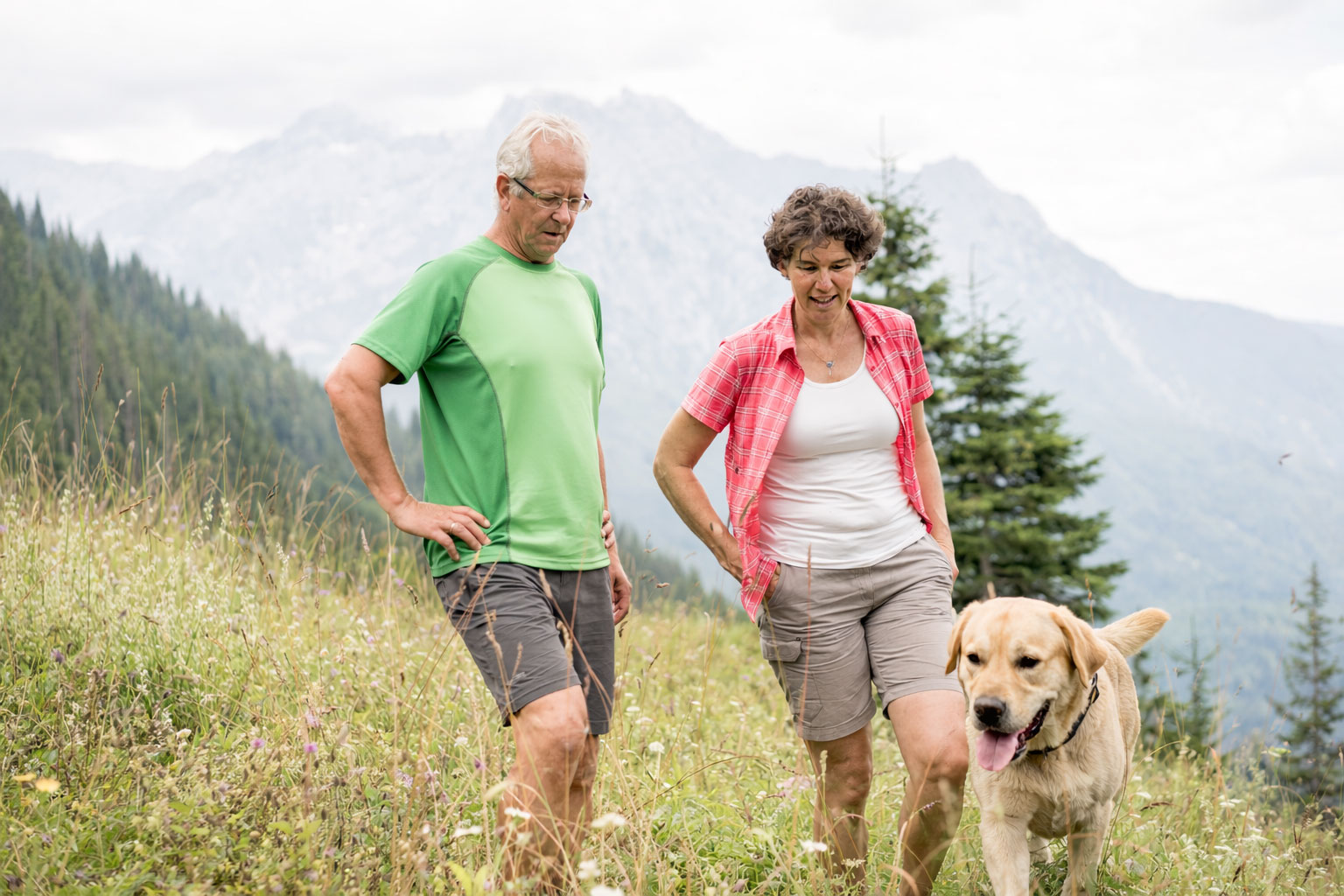 Waidringer Hof in Waidring – Wanderndes Paar mit Hund in den Tiroler Bergen | Wellnesshotel Tirol