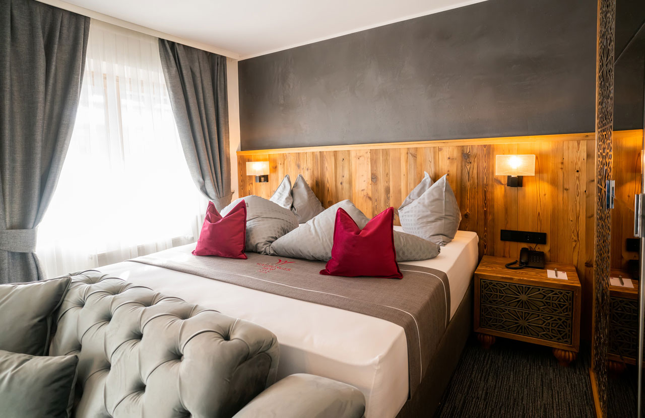 Waidringer Hof in Waidring – Gemütliches Hotelzimmer mit großem Bett und Holzelementen | Wellnesshotel Tirol