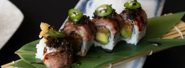 Exquisites Sushi mit Trüffel und Avocado, serviert auf einem Bananenblatt im Restaurant des Hotel Lausanne Palace.