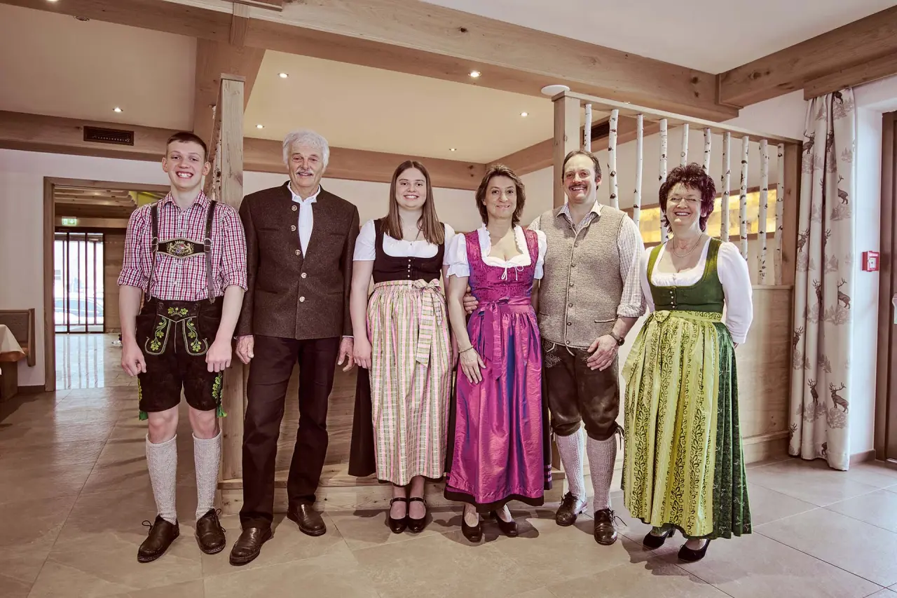Die Gastgeberfamilie des Naturhotel Reissenlehen in traditioneller Tracht im einladenden Lobbybereich.
