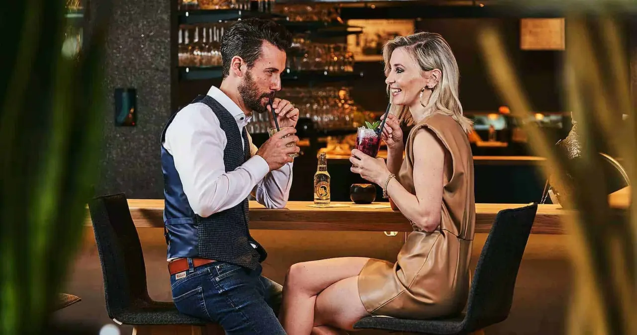 Paar genießt Cocktails an der stilvollen Bar im Wellness Hotel Zum Bräu, eine entspannte Abendstimmung.