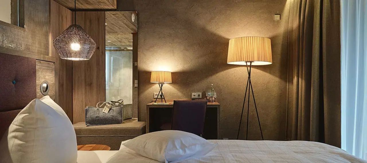 Gemütliches Hotelzimmer im Wellness Hotel Zum Bräu mit modernem Design, bequemen Betten und stimmungsvoller Beleuchtung.