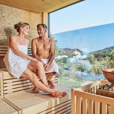 Paar entspannt in der Panorama-Sauna mit Ausblick im Wellness Hotel Zum Bräu.