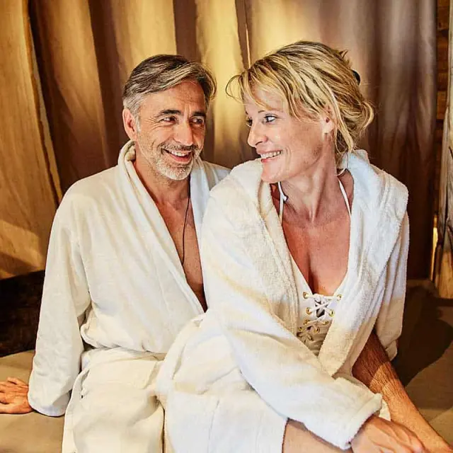 Glückliches Paar in Bademänteln genießt Entspannung im Wellness Hotel Zum Bräu.