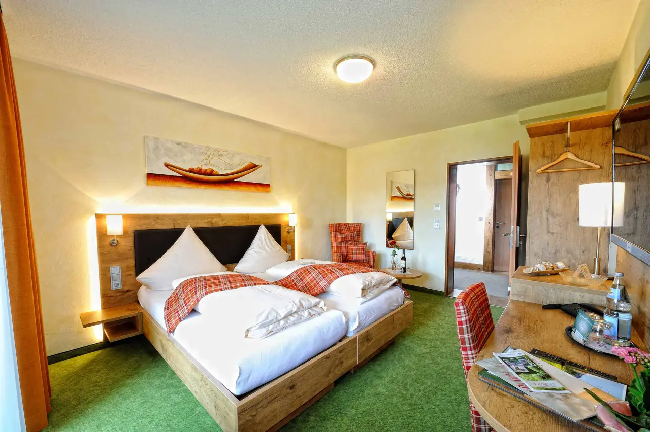 Gemütliches Doppelzimmer mit Holzbett und Schreibtisch im Wellness-Hotel Cafe Talblick.