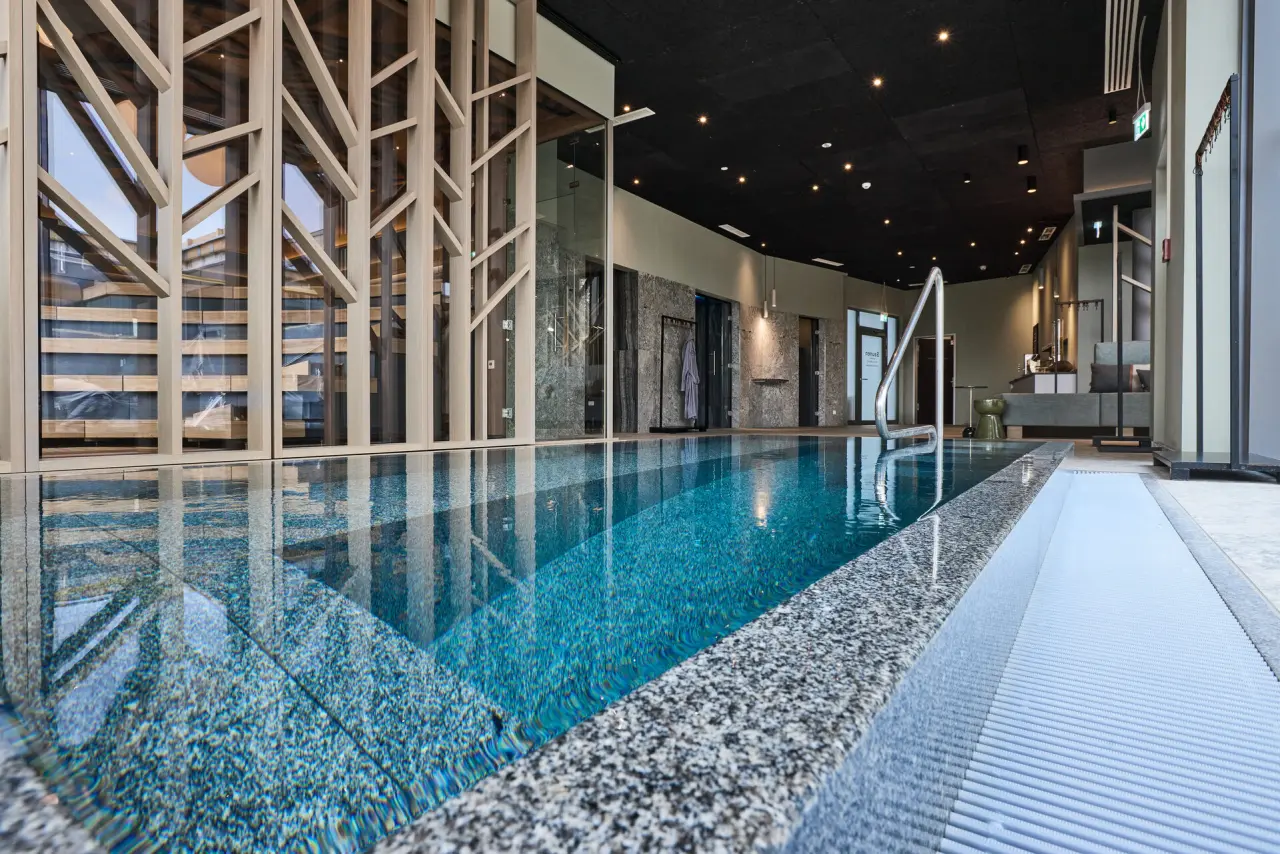 Moderner Innenpool mit Holzdesign und entspannender Atmosphäre im Wellnessbereich des Hotel Holzapfel.