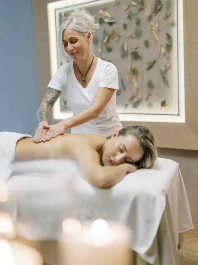 Entspannende Rückenmassage im Spa-Bereich des Garten-Hotel Ochensberger mit Kerzenschein.