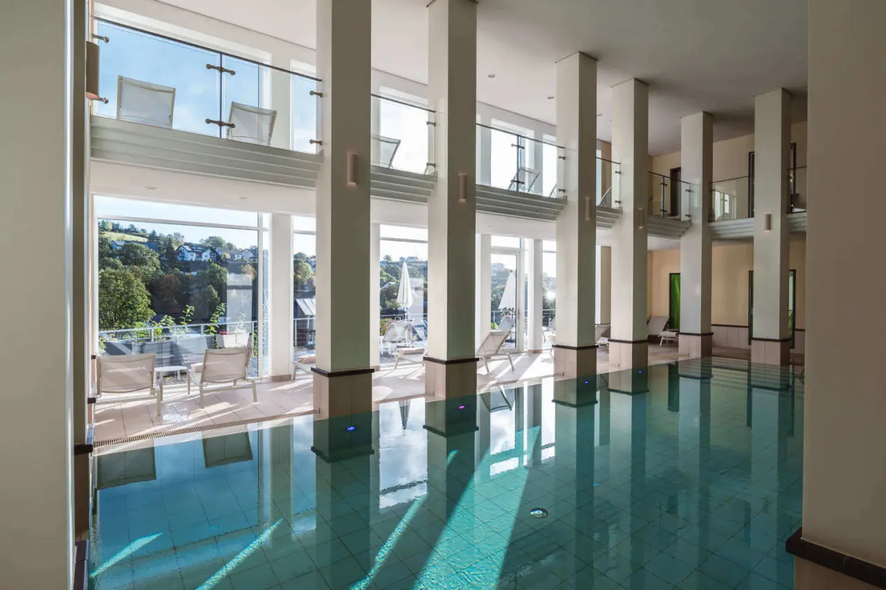 Grosszügiger Innenpool mit grossen Panoramafenstern und Blick ins Grüne im DIEDRICH Wellnesshotel & SPA.