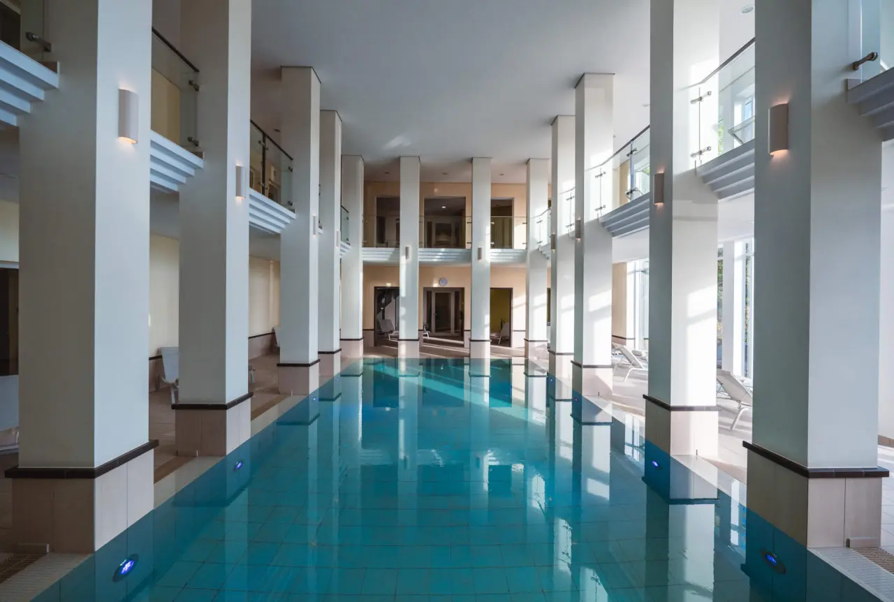 Grosszügiger Innenpool mit Säulenarchitektur und Tageslicht im DIEDRICH Wellnesshotel & SPA.