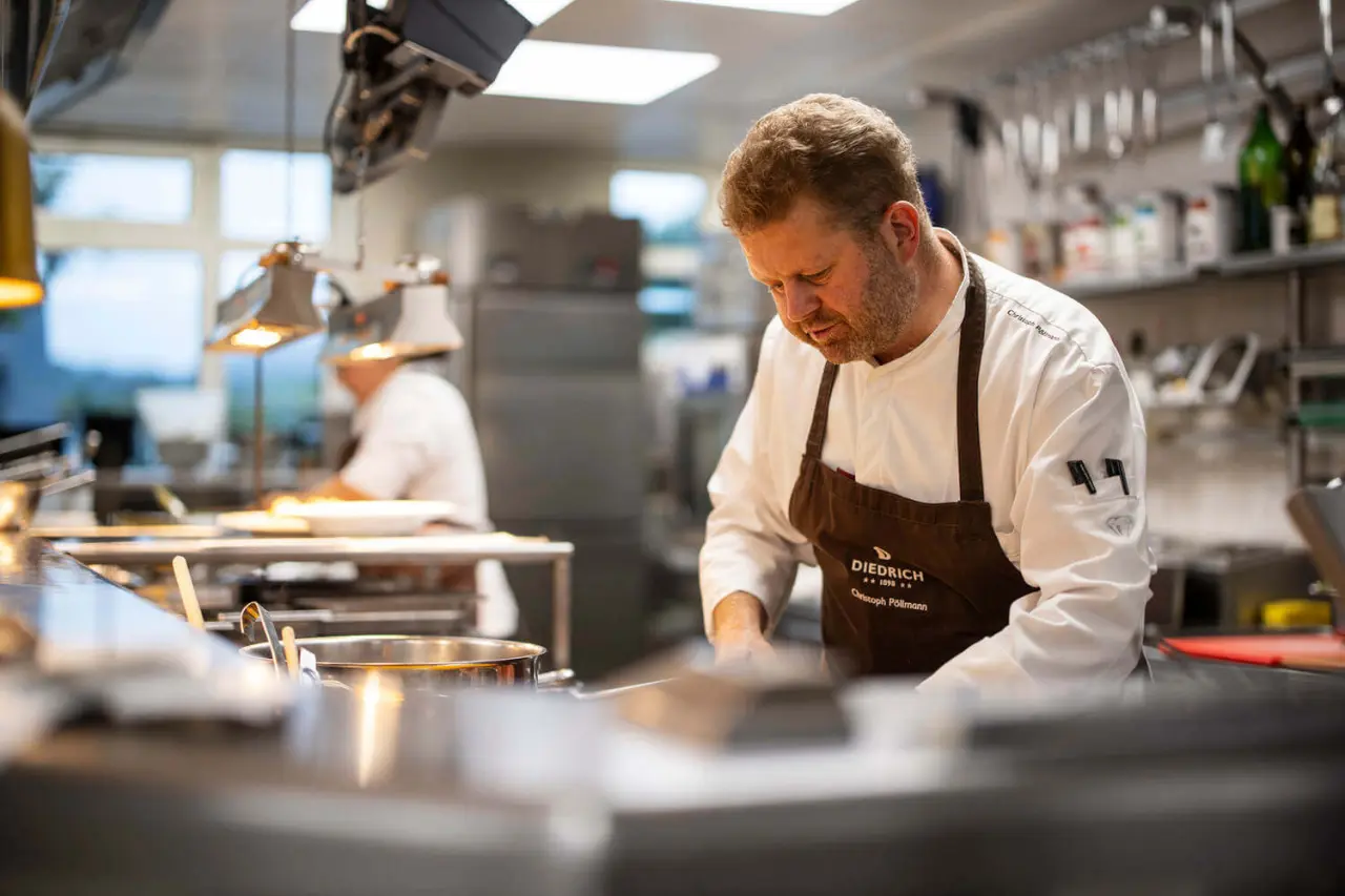 Küchenchef Christoph Pollmann in der professionellen Küche des DIEDRICH Wellnesshotel & SPA bei der Speisenzubereitung.