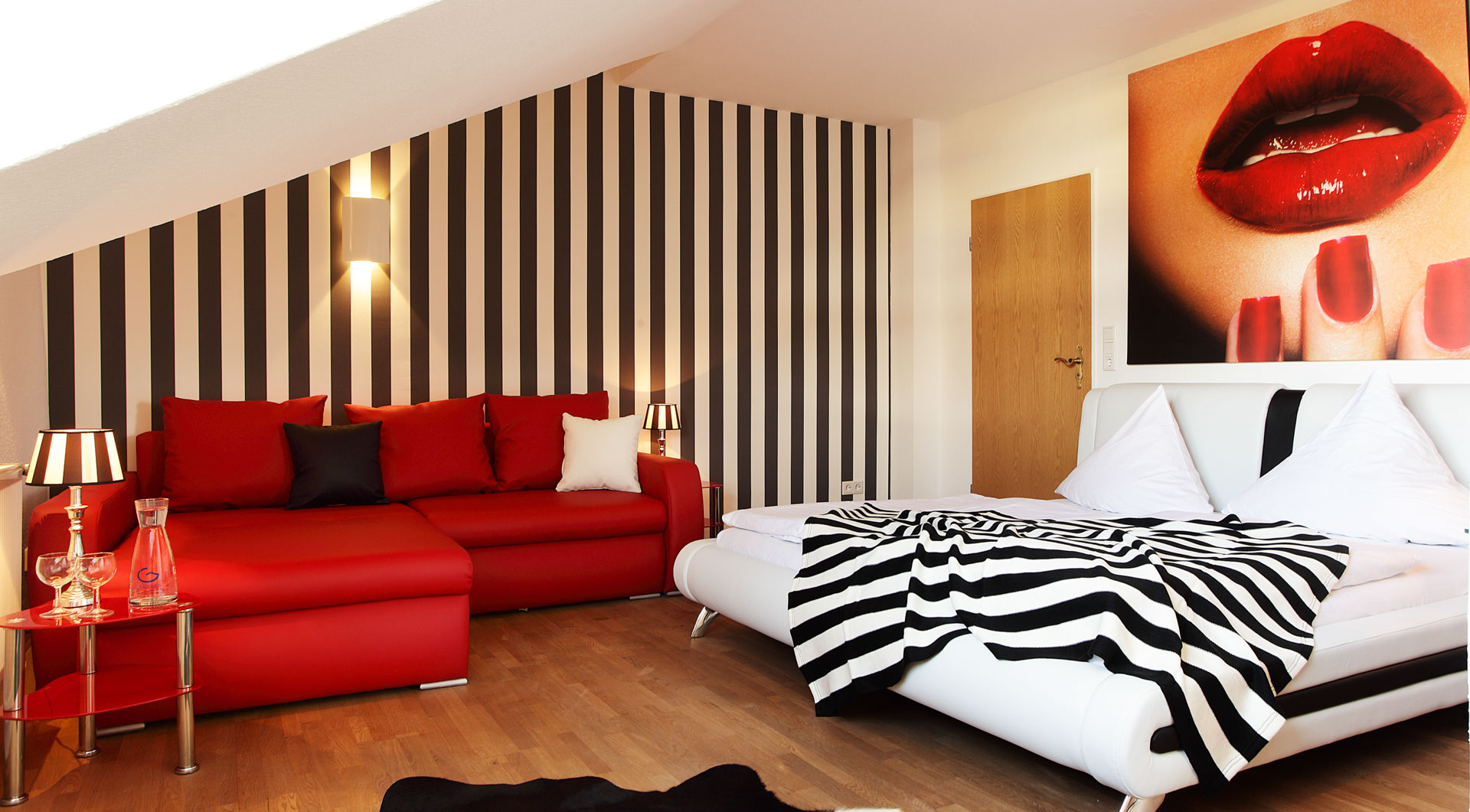 Hotel Wulff in Bad Sassendorf – Modernes Hotelzimmer mit rotem Sofa und Streifenmuster | Wellnesshotel Sauerland